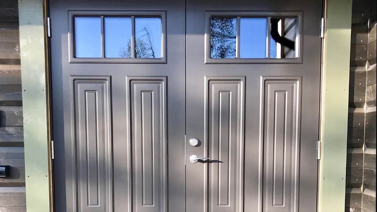 Hytte med grå tofløyet hyttedør.