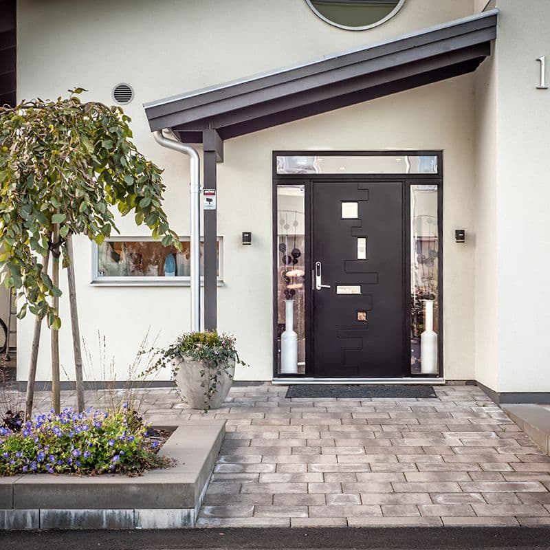 hvitt murhus med sort ytterdør