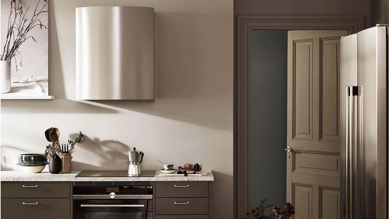 Kjøkkenhette som går ton-i-ton med veggen i et brunt og lyst kjøkken.