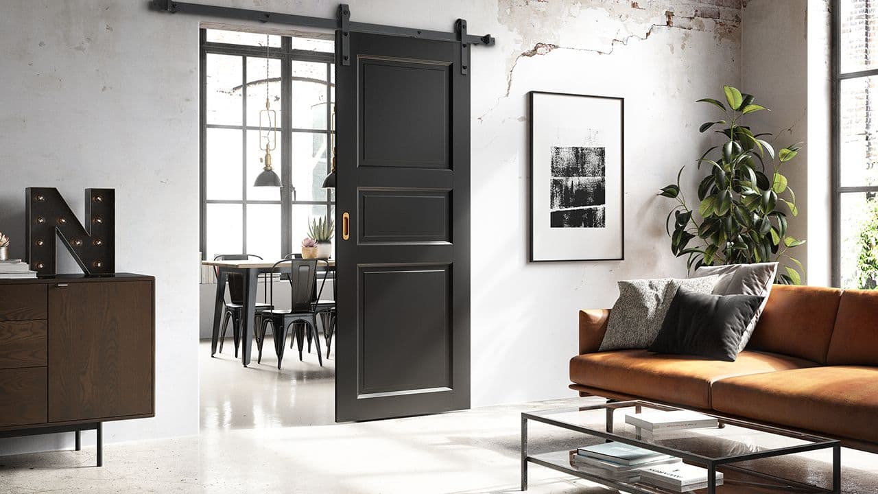 Rustikk stue med sort innerdør med skyvedør og gull detaljer.