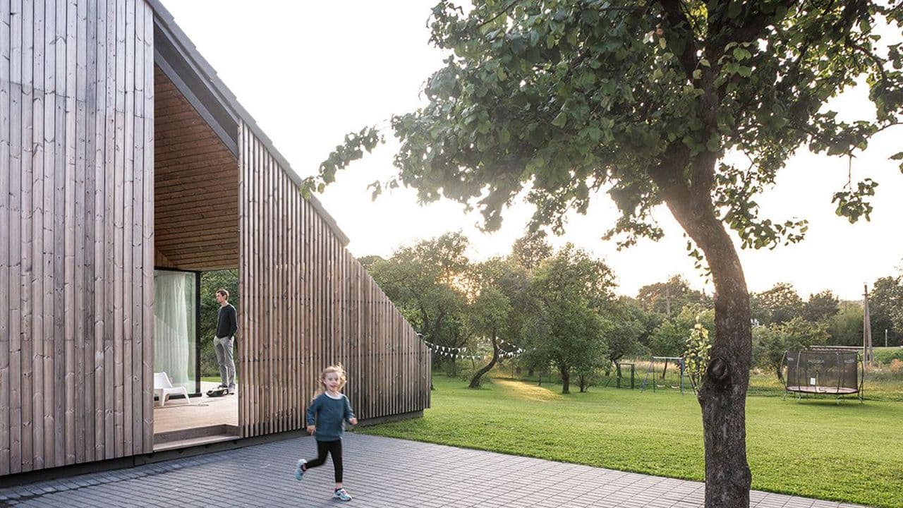 Moderne hus med termofuru kledning og barn som leker utenfor.