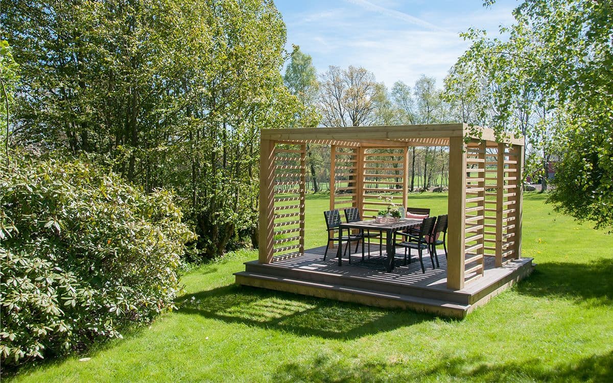 Inspirasjon norsk hage med stor pergola med sitteplass.