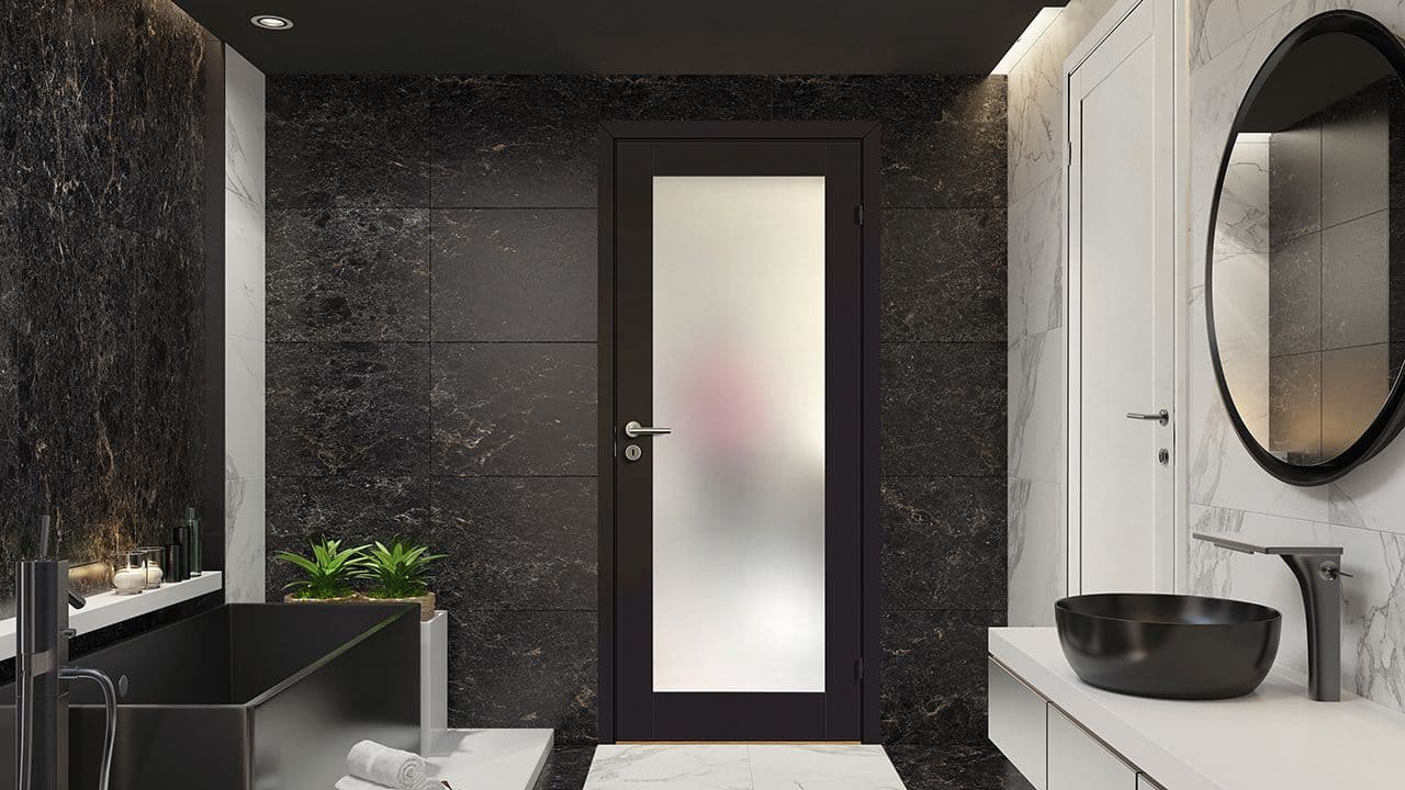 Sort glassdør innendørs på badet.
