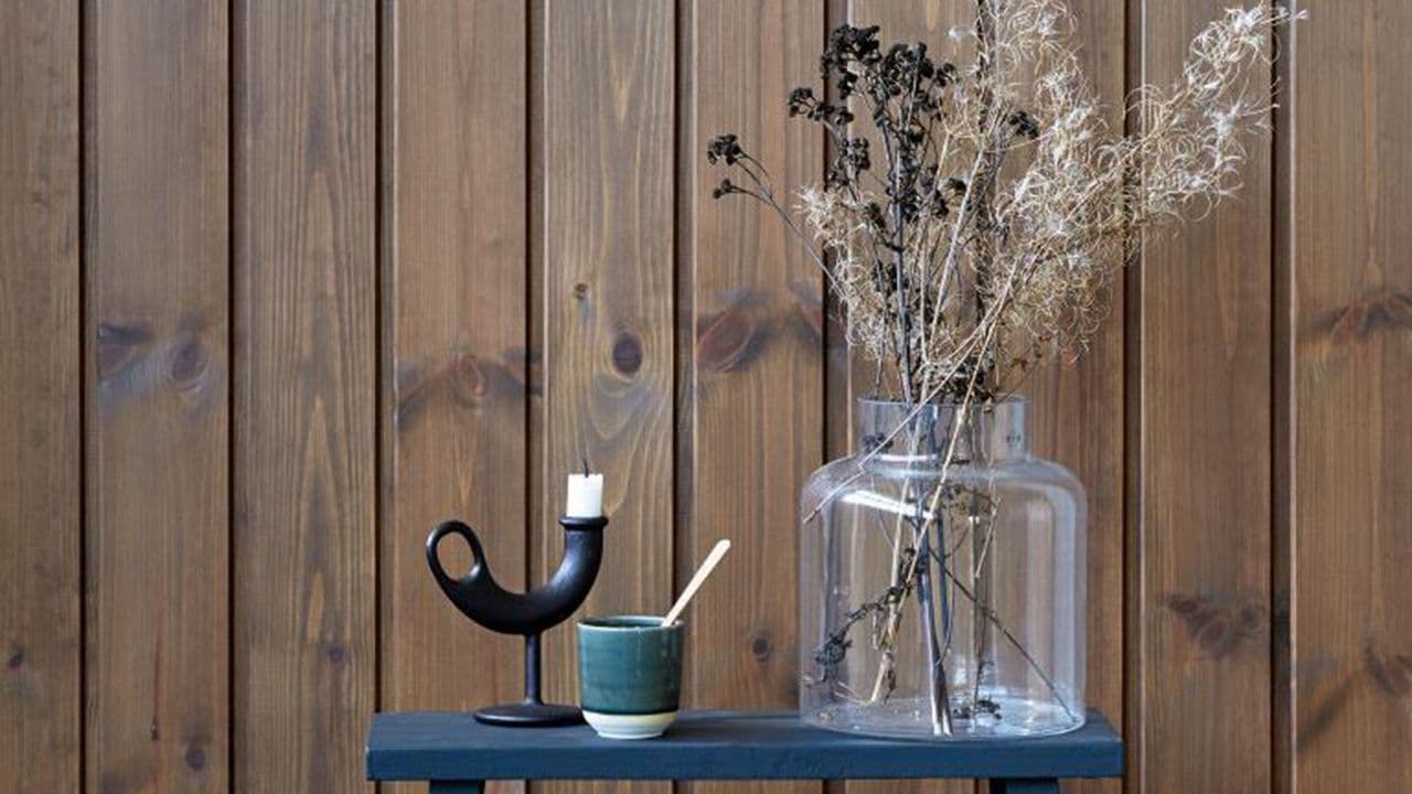 Blå krakk foran vegg med interiørbeis.