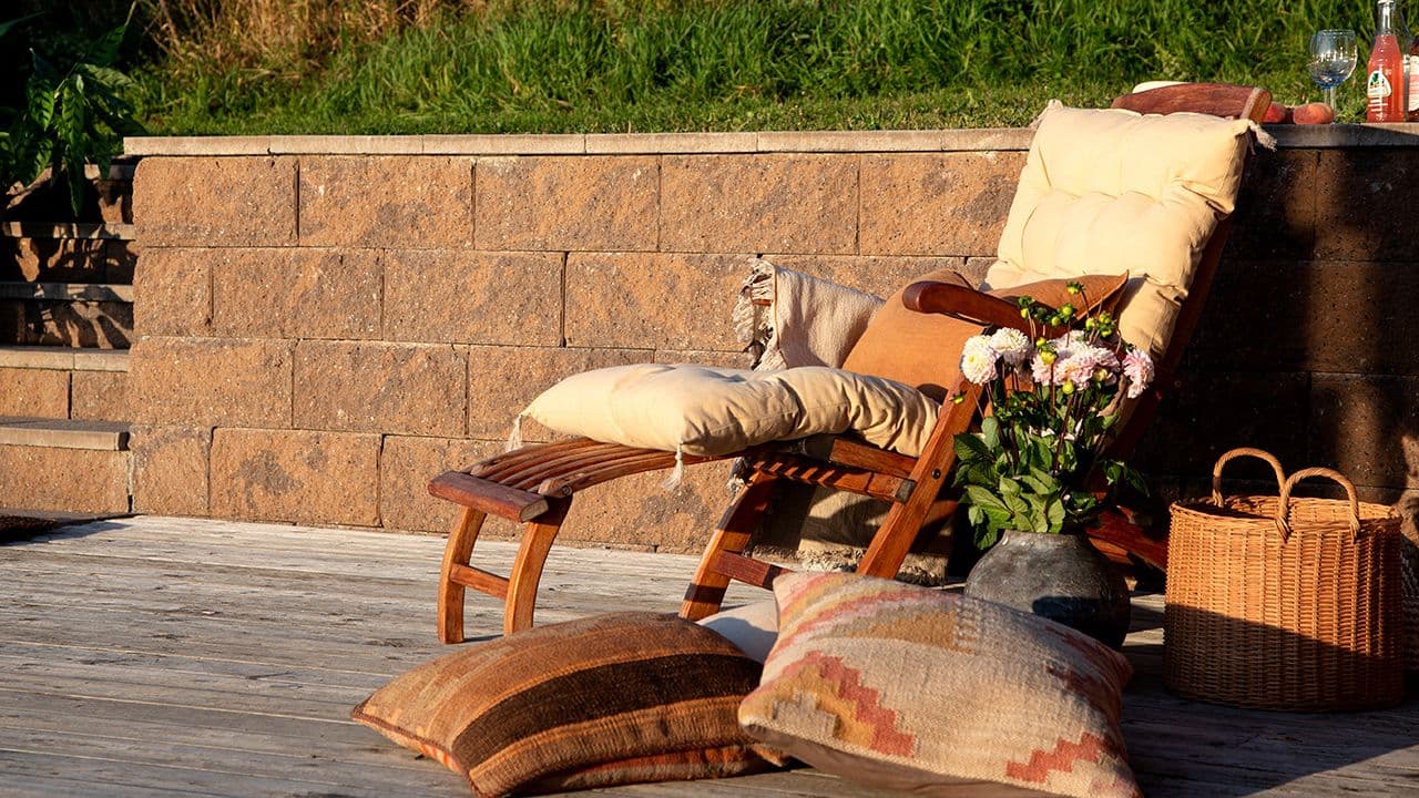 Vertica steinmur som støttemur i hage ved nivåforskjeller mellom gressplen og platting.