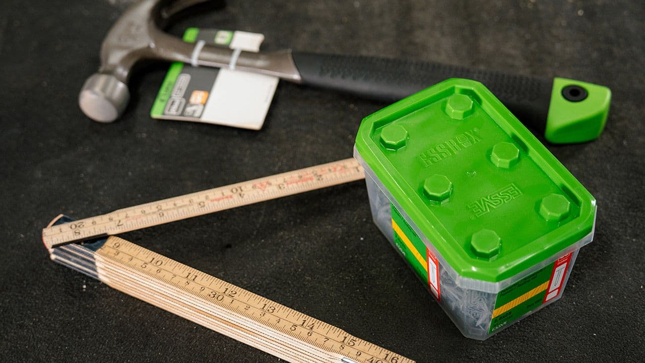 Hammer, meterstokk og pappspiker for å legge takshingel.