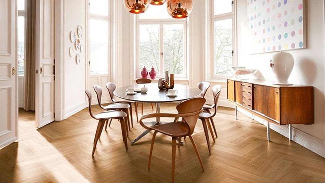 Fiskebensparkett i herskapelig spisestue med moderne møbler.