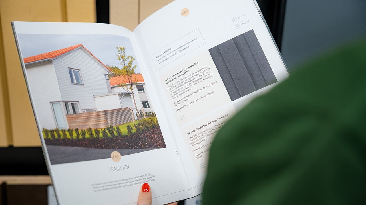 Person som viser frem katalog med kledning.