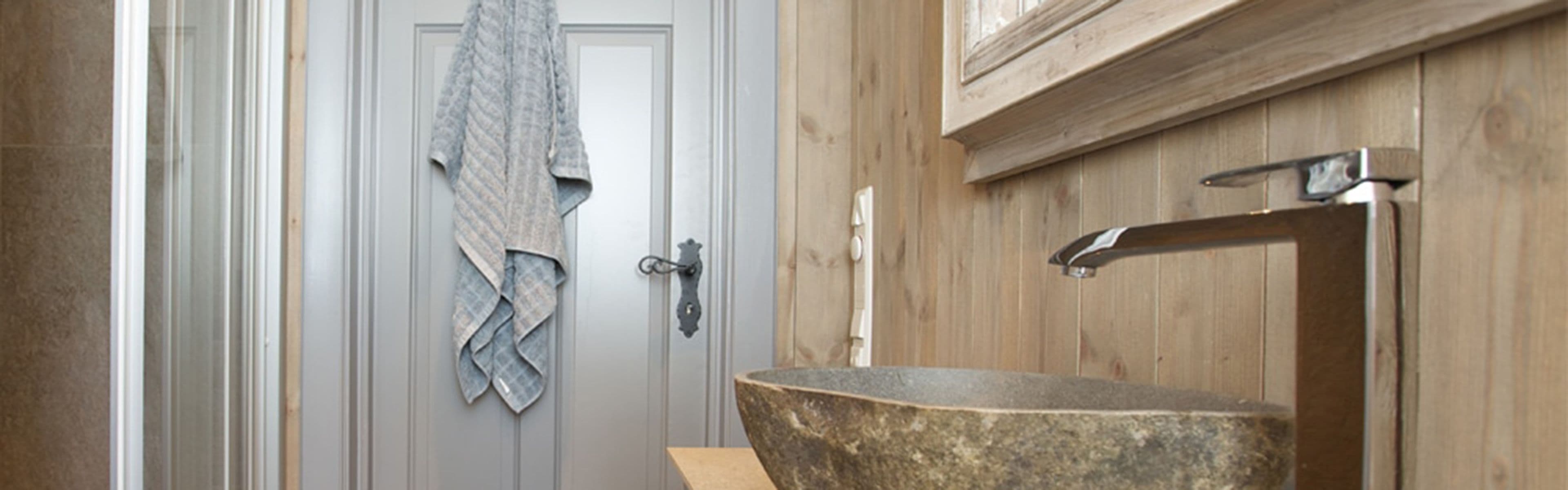 Lite hyttebad med lys trepanel på veggene.