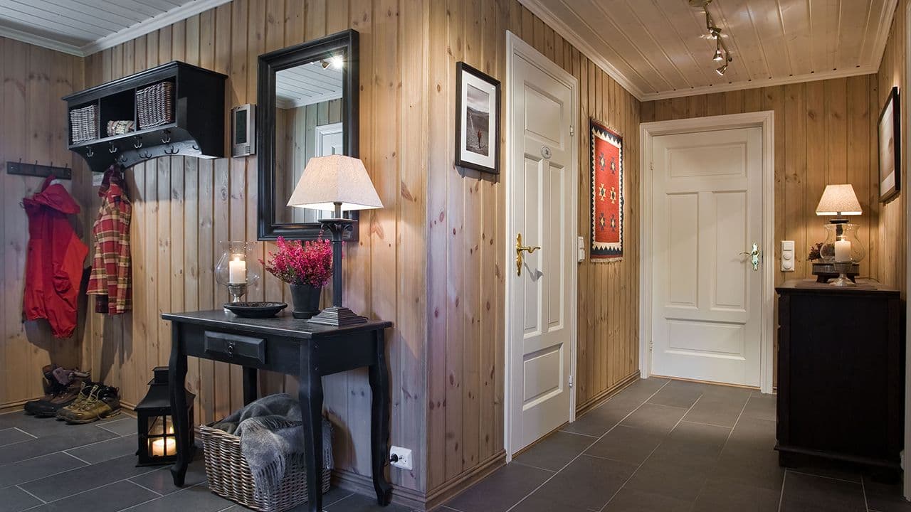 Gang/entré i hytte med furuvegger og gulvfliser