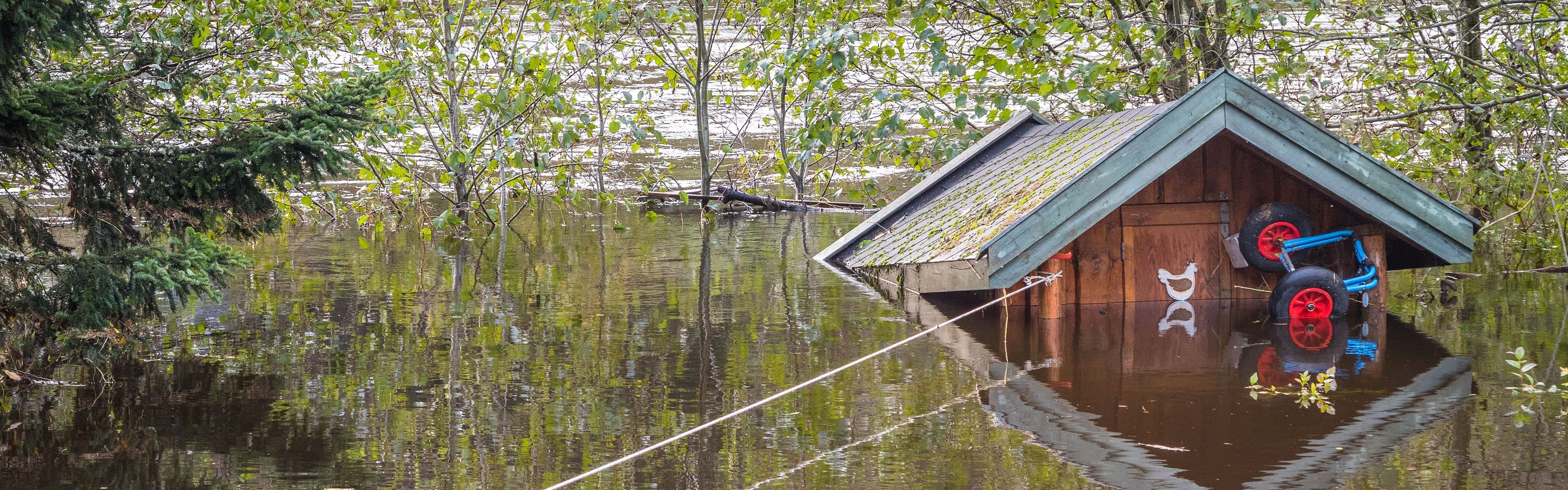 Lite bygg som står under vann og som får vannskader.