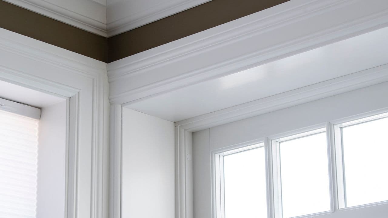 Hvite brede lister rundt vindu.