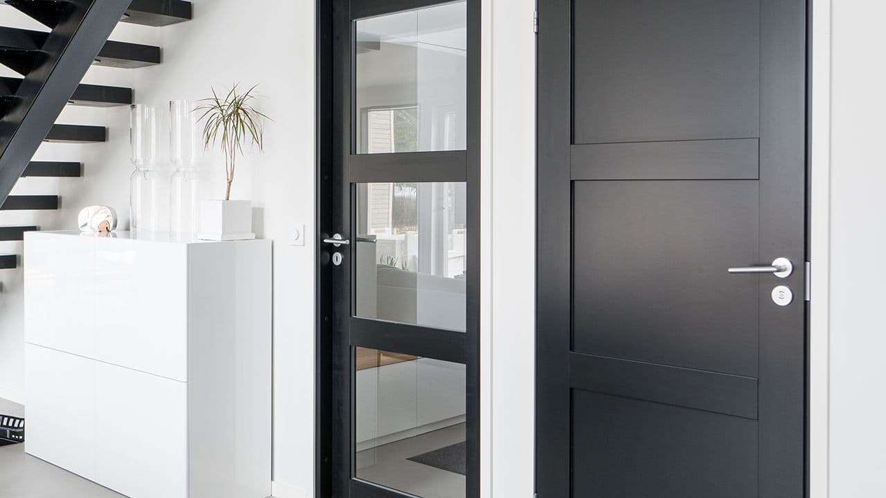 To sorte innerdører, en med glass og den andre er profilert.