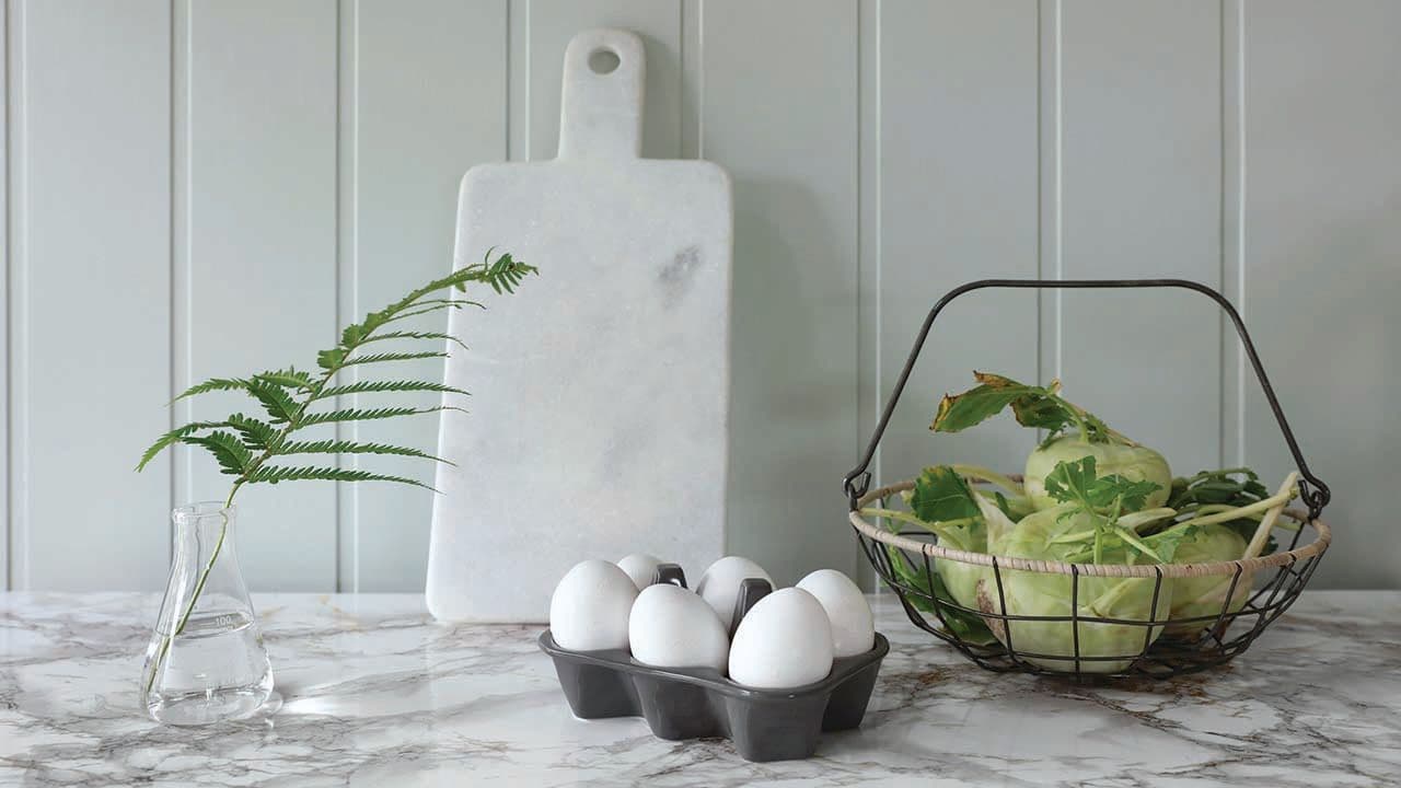 Huntonitt veggplater i Soft Menthol fra Byggma over kjøkkenbenk med benkeplate i stein.