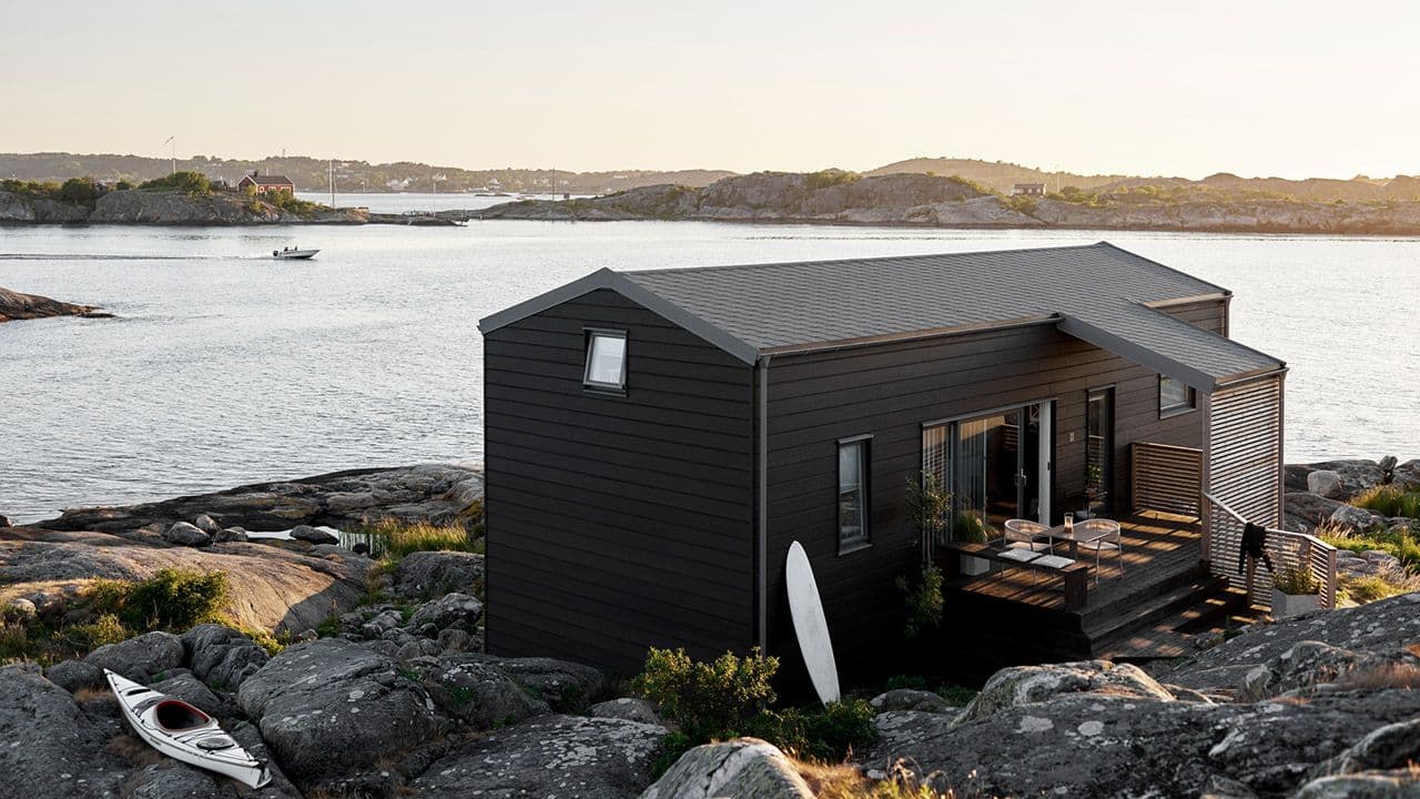 Hus ved vannet malt i JOTUN 9938 Dempet sort og TREBITT Terrassebeis 90002 Gråsvart.