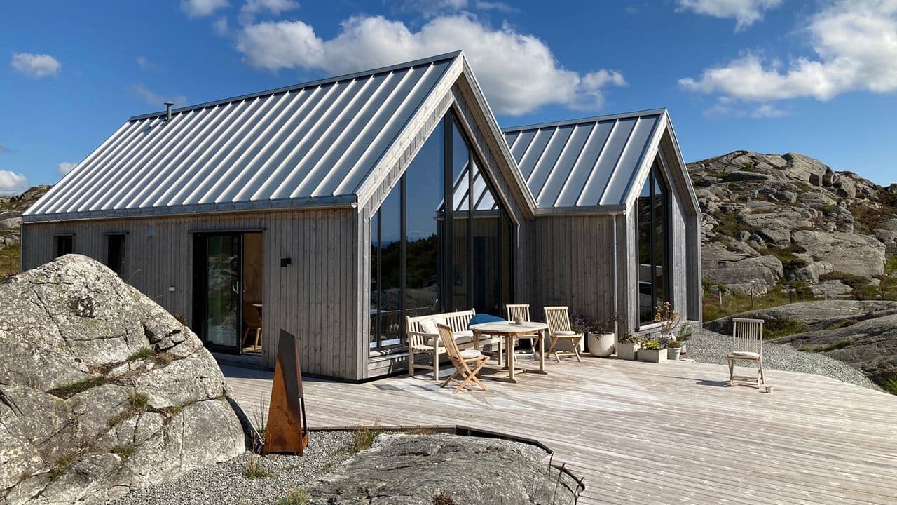 Utvendig foto av hytte ved sjøen med NorDan-vindu.