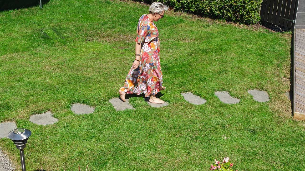 Kvinne som går på heller på plen.