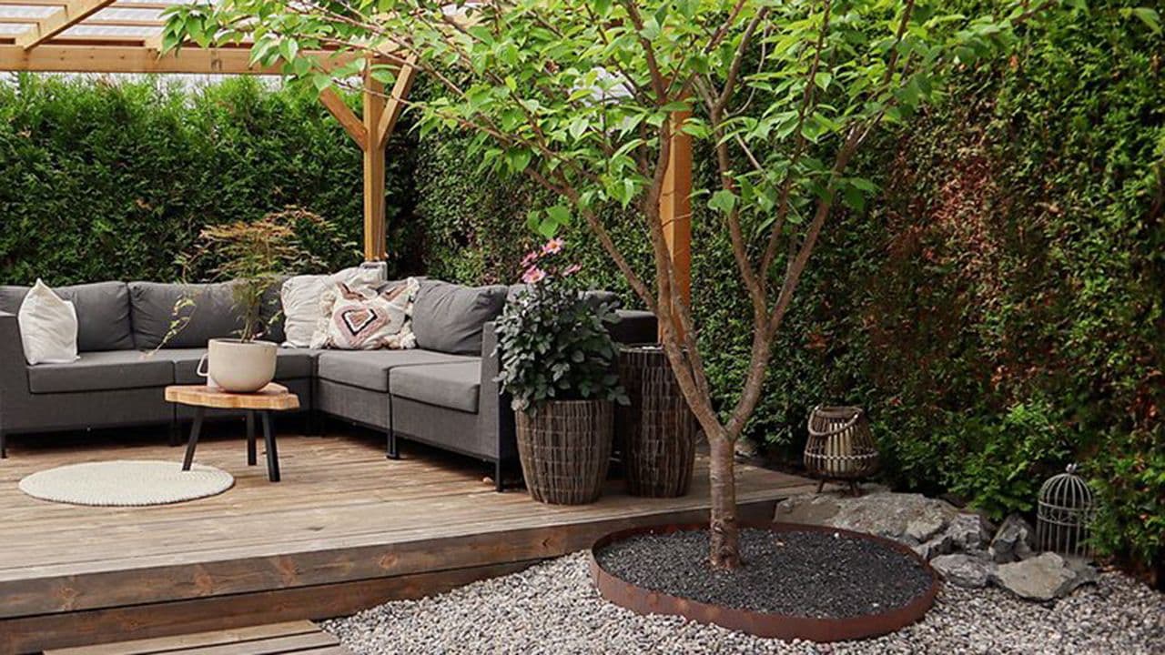 Koselig hage med heller, dekorstein og platting.