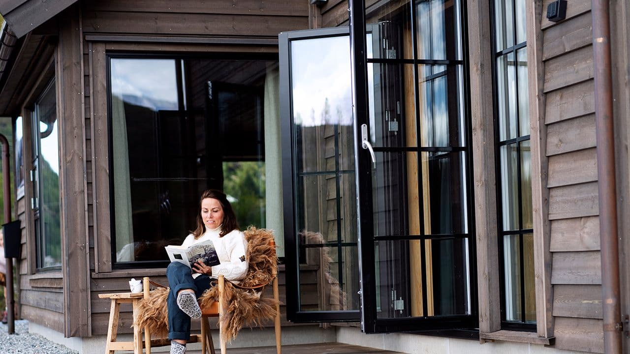 Hytte med dobbel verandadør i sort med sprosser.